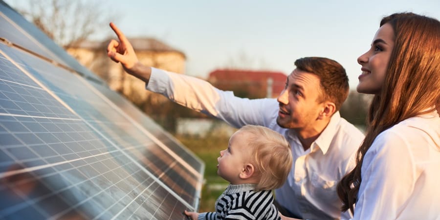 Q CELLS Solaranlage Baufamilie mit Kind betrachten Solarmodule