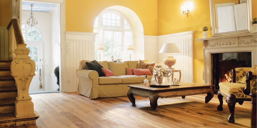 Amerikanischer Landhausstil Wohnzimmer mit gelben Wänden und Holzfußboden.