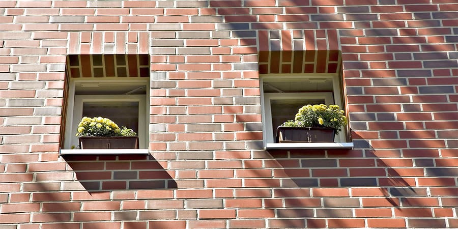 Mauer aus rotem Klinker mit Fensteraussparungen