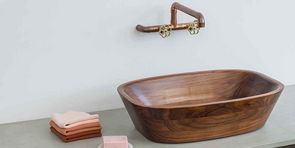 Holzwaschbecken in einem Bad mit Kupferaramtur