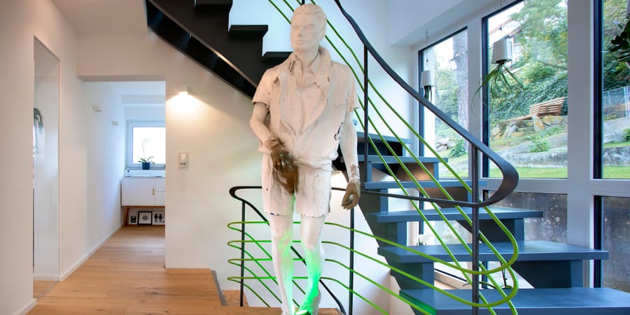 Treppe mit grünem Anstrich und weißer Statue davor