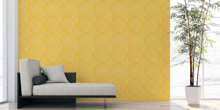 Gelbes Imitat einer Textiltapete hinter grauer Couch