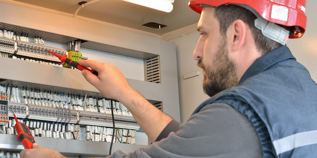 Fachmann für Elektroinstallationen bei der Arbeit an Stromkasten. Foto: iStock/Shinyfamily