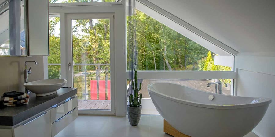 Badezimmer mit freistehender Badewanne und bodentiefen Fenstern