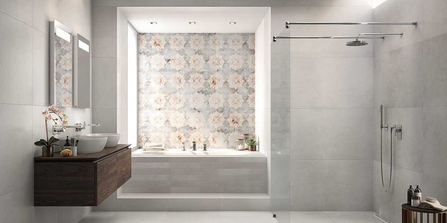 Badezimmer mit schlichten grauen Fliesen und einem Mosaik als Akzent hinter der Badewanne