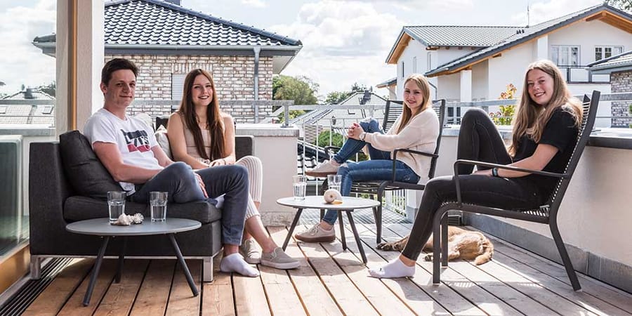 Kinder von Familie Assmann sitzen auf der Terrasse ihres Hauses