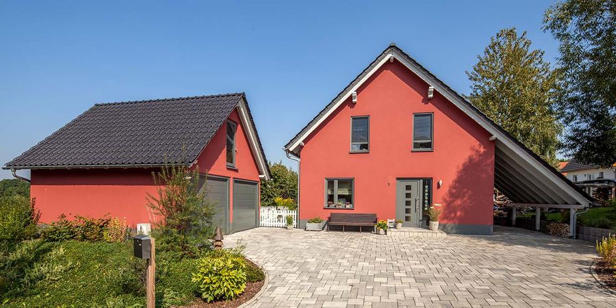 Baumeister-Haus im modernen Landhausstil mit roter Fassade