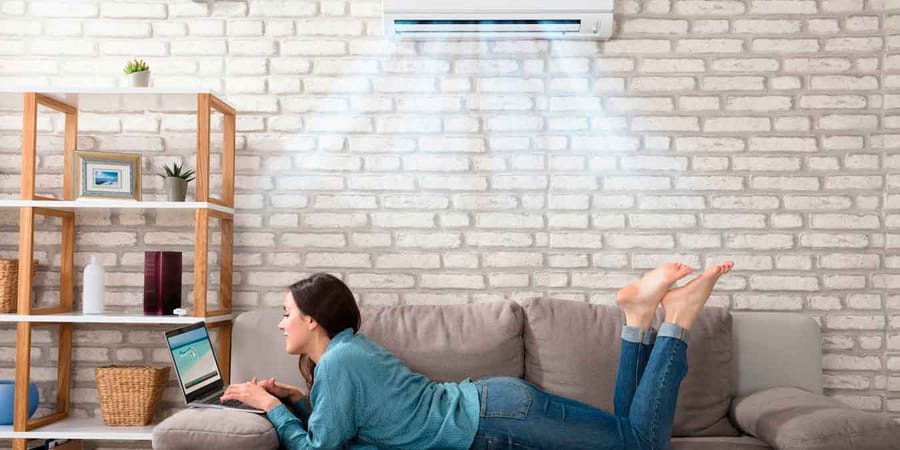 Frau auf Couch in einem Wohnzimmer mit Klimaanlage