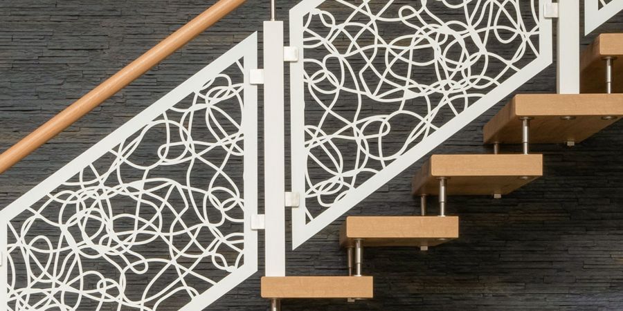Treppe mit ausgefallenem Geländer-Design in weiß mit Holz-Handlauf.