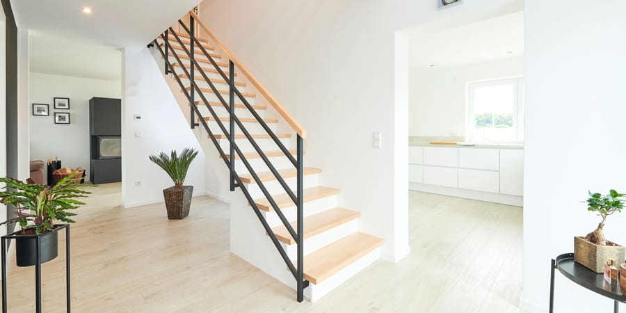 Treppe in weiß mit Holzstufen und Metallgeländer