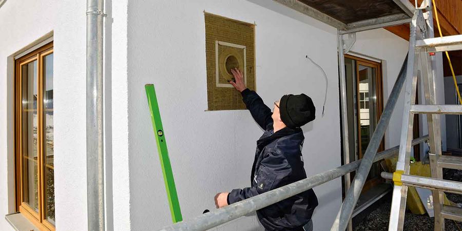 Schornstein nachträglich einbauen: Handwerker prüft Wanddurchführung