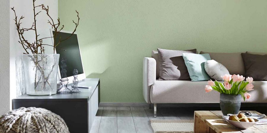Wohnzimmer mit verputzten Wänden in Grau und Olivgrün