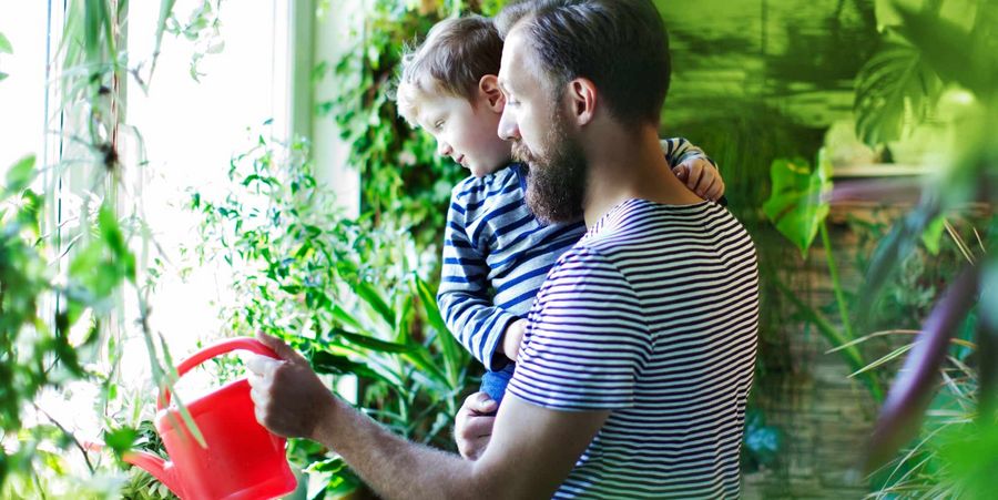 Wintergarten selber bauen - Sohn und Vater mit roter Gießkanne