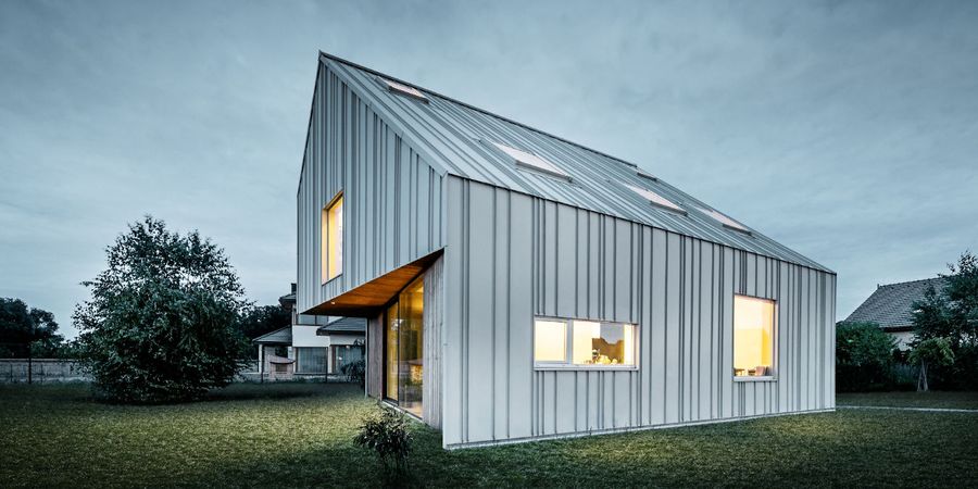 Außergewöhnliches Design: Modernes Einfamilienhaus mit Satteldach mit heller Metallfassade aus Aluminium