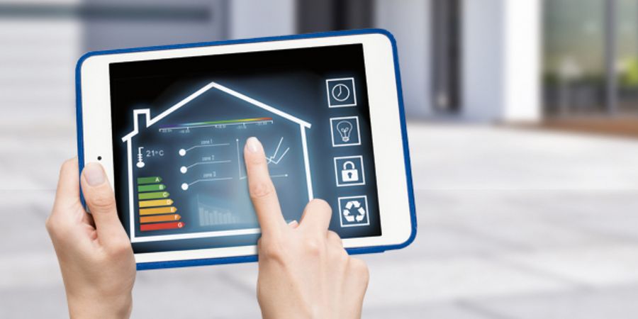 Tablet mit Smart-Home-Funktionen und Haus im Hintergrund