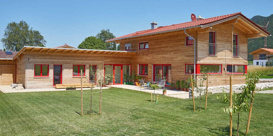 Holzhaus mit roten Fenstern