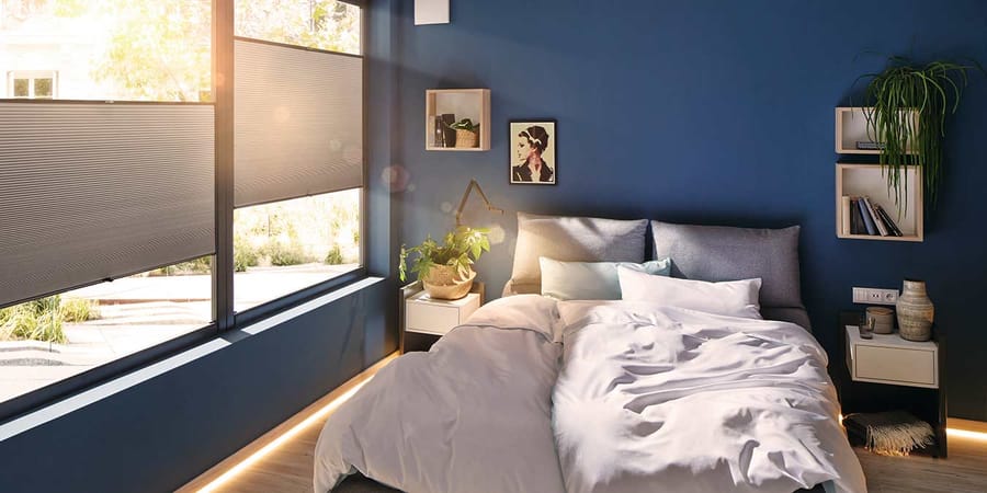 Schlafzimmer mit Faltstores an den Fenstern als Blickschutz