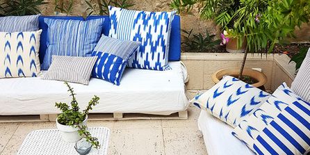 Garten Loungemöbel Outdoor-Sofa mit blau-weißen Kissen.