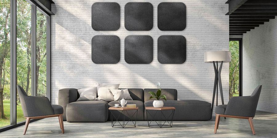 Wohnzimmer mit großen, quadratischen Wandpaneelen in Schwarz aus Schafwolle an der Wand über der Couch