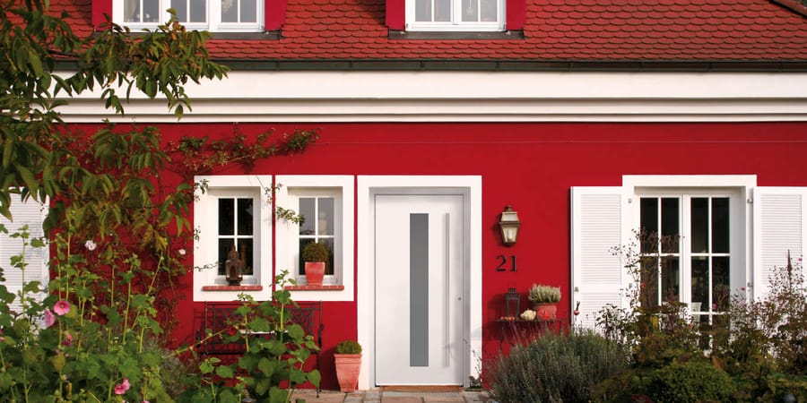 Weiße Haustür an rotem Haus im skandinavischen Stil