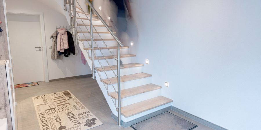 Nach dem Treppenaustausch: Eine moderne Treppe mit Holzstufen und Metallgeländer.