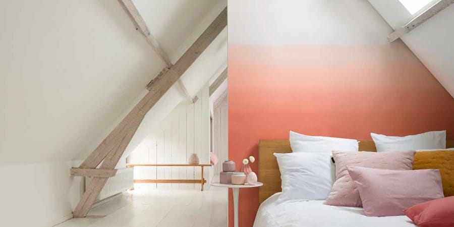 Schlafzimmer mit Wand mit Farbverlauf in Orangetönen.