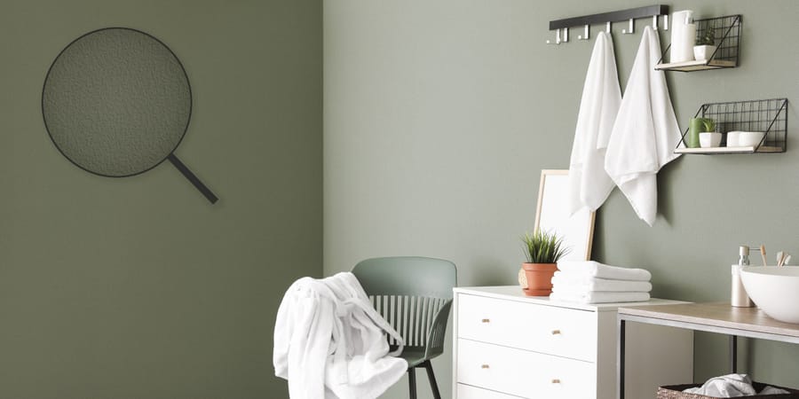 Raum mit überstreichbarere Papiertapete ohne Schadstoffe in Olivgrün mit weißen Möbeln