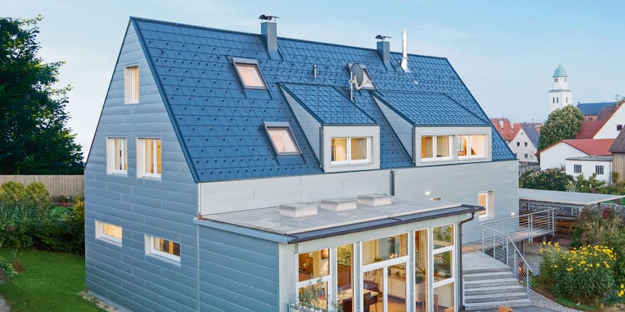Haus mit Aluminiumdach mit Dachfenstern und Gauben