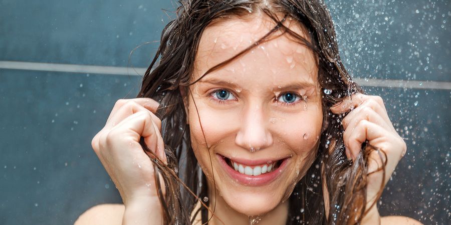 Lächelnde Frau unter der Dusche