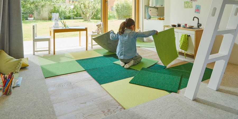Grüne und gelbe wohngesunde Teppichboden, die ohne Kleber am Boden liegen.