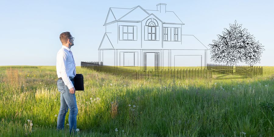Mann vor einem Grundstück mit visualisiertem Haus.