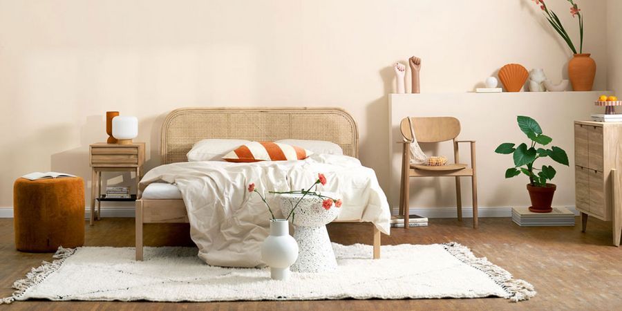 Schlafzimmer mit Bett vor einer beigefarbenen Wand