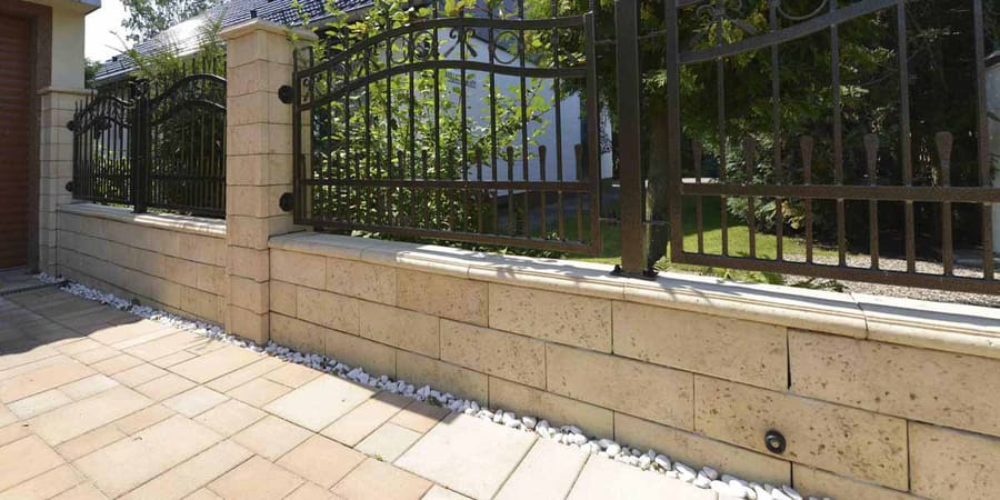 Travino-Mauer als Einfriedung mit Zaun