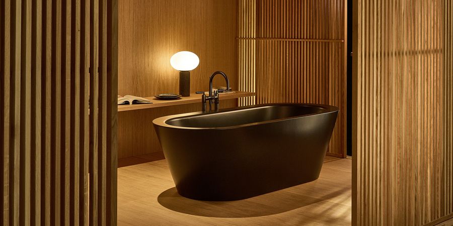 Freistehende Badewanne in einem Badezimmer mit Holzwänden