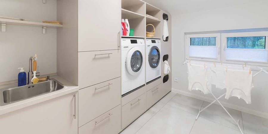 Hauswirtschaftsraum mit Waschmaschine, Trockner und extra Waschbecken