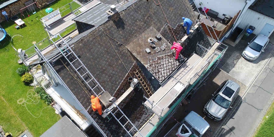 Handwerker entfernen den Asbest fachgerecht vom Dach.