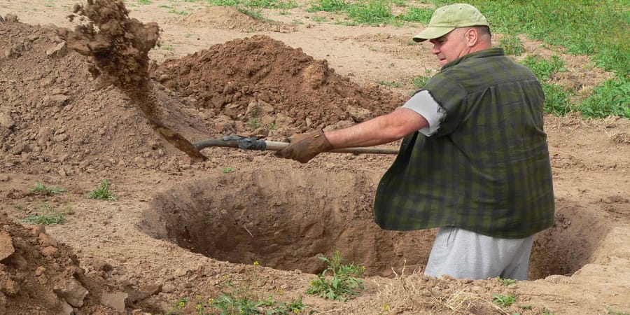 Mann gräbt Loch für einen Luftbrunnen.